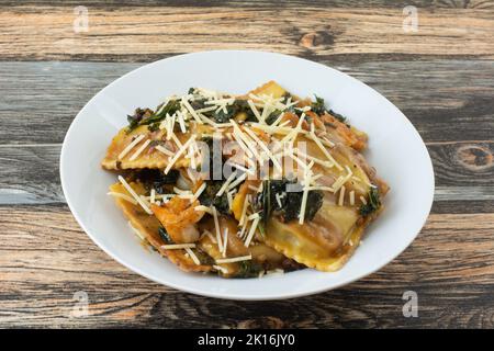 Raviolis aux champignons et au fromage, avec kale et crevettes dans un bol blanc Banque D'Images