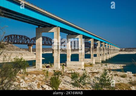 PONT ROUTIER ET ferroviaire US-90 traversant le réservoir Amistad, niveau d'eau très bas en avril 2022, marques de haut niveau visibles sur les jetées, près de Del Rio, TX Banque D'Images