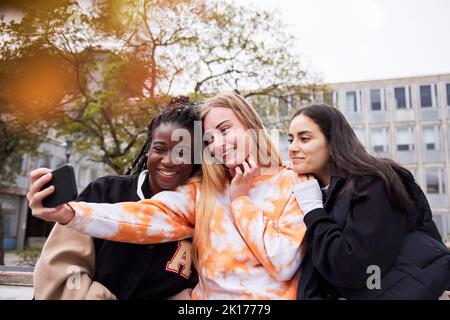 Trois jeunes étudiantes qui prennent le selfie sur le campus Banque D'Images