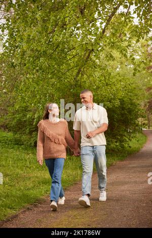 Heureux couple walking in park Banque D'Images