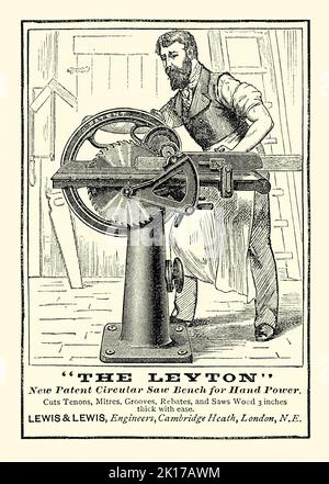 Une vieille publicité victorienne pour ‘The Leyton’, une scie à banc circulaire à main, réalisée par Lewis et Lewis de Cambridge Heath, Londres, Angleterre, Royaume-Uni. Il est d'un magazine de 1890. La scie pourrait couper le bois et aider à faire des tenons, des mitaines et des rabais. Le travailleur de son atelier fait tourner la scie par une roue dentée à l'aide de sa main droite tout en alimentant le bois vers la lame de scie avec sa gauche. Il porte un tablier en cuir robuste – vieux graphiques de 1800s. Banque D'Images