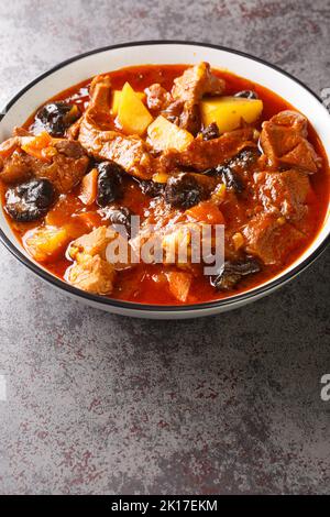 Perse Plum Stew Khoresht Aloo avec agneau en gros plan dans le bol sur la table. Verticale Banque D'Images