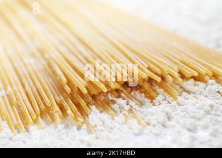 Gros plan de pâtes spaghetti crues avec de la farine. dof étroit Banque D'Images