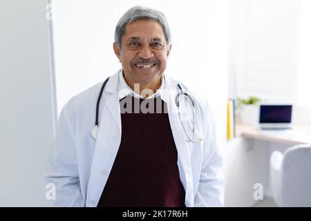 Portrait d'un médecin biracial senior souriant avec stéthoscope portant un manteau blanc Banque D'Images