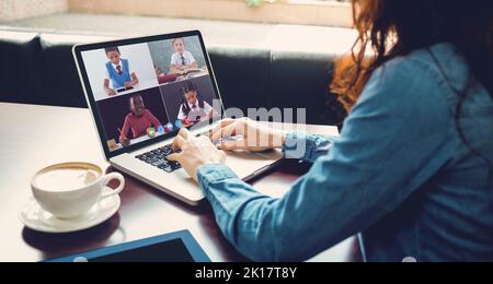 Une enseignante caucasienne donne une leçon en ligne aux élèves. À la maison, en isolement pendant le confinement en quarantaine. Banque D'Images
