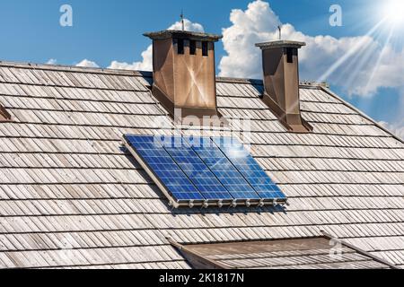 Gros plan d'un groupe de panneaux solaires au-dessus du toit en bois d'un chalet, Energies renouvelables concept. Autriche, Europe. Banque D'Images