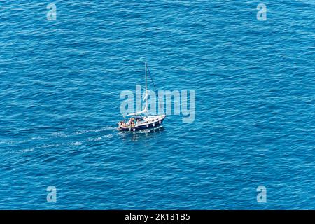 Vue aérienne d'un petit bateau à voile avec un petit groupe de personnes à bord, dans la mer Méditerranée bleue, Golfe de la Spezia, Ligurie, Italie, sud Banque D'Images