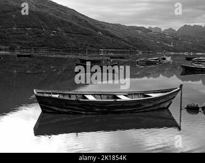 Un bateau en bois se reflète dans le lac de Santa Croce, en Italie Banque D'Images