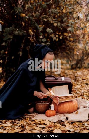 Une jeune femme dans les bois pratique la magie d'Halloween Banque D'Images
