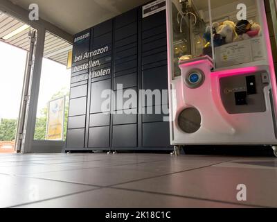 Berlin, Allemagne - 27 août 2022 : vue à angle bas d'Amazon Locker - version noire dans la station-service de Berlin - distributeur de jouets à côté Banque D'Images