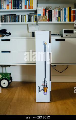 Paris, France - 16 juillet 2022 : boîte en carton ouverte contenant un nouvel aspirateur sans fil à piles de Dyson V12 SLIM Absolute avec étagères Vitsoe en arrière-plan Banque D'Images