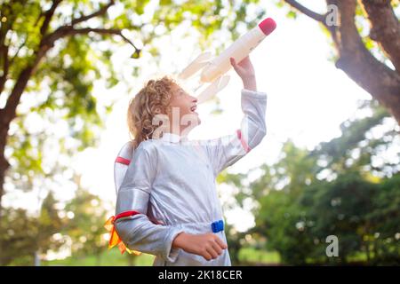 Petit garçon jouant avec vaisseau spatial. Costume d'astronaute pour Halloween. Enfant créatif avec fusée spatiale. Les enfants rêvent et imaginent. Banque D'Images