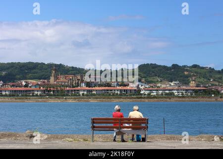 Un couple âgé regarde Hondarribia (Espagne) de l'autre côté de la rivière Bidasoa depuis Hendaye, pays basque français, France Banque D'Images