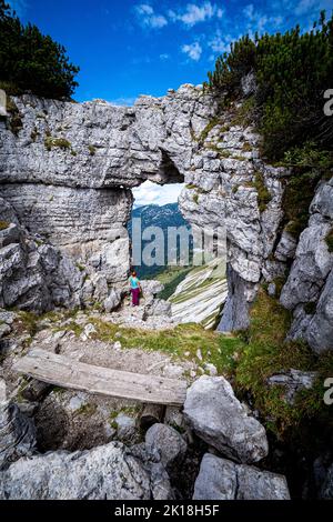 Femelle randonneur profitant de la vue à travers le soi-disant Loserfenster-fenêtre, une arche de roche sur la montagne du perdant, Ausseer Land, Styrie, Autriche Banque D'Images