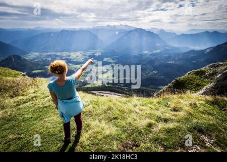 Le randonneur féminin bénéficie d'une vue à couper le souffle depuis le sommet de la montagne du perdant et pointe vers le sommet opposé, Altaussee, Ausser Land, Styrie, Autriche Banque D'Images