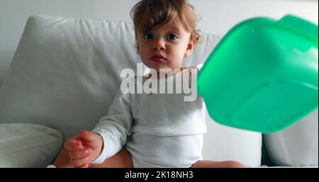 Bol de fin de nourriture pour bébé assis sur un canapé, mignon petit garçon d'un an Banque D'Images