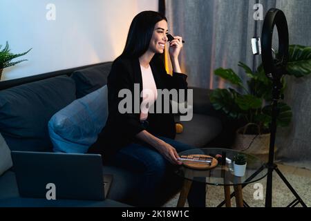 Jeune femme qui vante en ligne avec smartphone CAM et anneau conduit de la maison - les gens du millénaire avec les médias sociaux et le concept de travail intelligent Banque D'Images