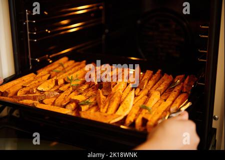 Concentrez-vous sur des tranches de batata, des patates douces, assaisonnées d'épices et d'herbes culinaires, arrosées d'huile d'olive Banque D'Images