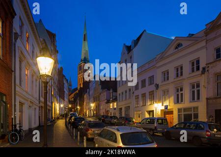 L'église gothique de brique Jakobikirche / Saint Jakobi et rue avec des maisons historiques dans la ville hanséatique de Lübeck la nuit, Schleswig-Holstein, Allemagne Banque D'Images