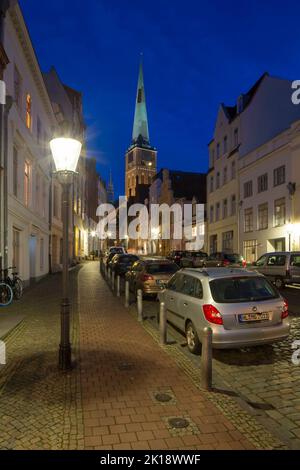 L'église gothique de brique Jakobikirche / Saint Jakobi et rue avec des maisons historiques dans la ville hanséatique de Lübeck la nuit, Schleswig-Holstein, Allemagne Banque D'Images