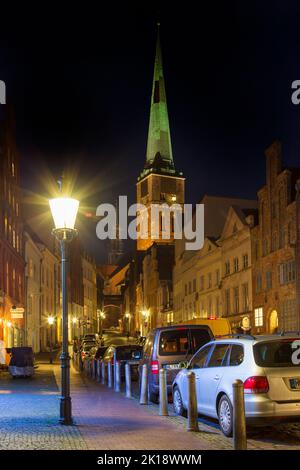 L'église gothique de brique Jakobikirche / Saint Jakobi et rue avec des maisons historiques dans la ville hanséatique de Lübeck la nuit, Schleswig-Holstein, Allemagne Banque D'Images