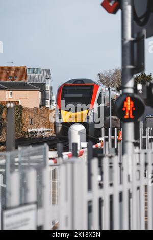 Un train britannique se tirant à un passage à niveau Banque D'Images