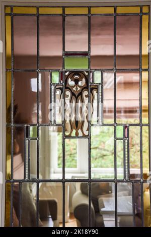 Piano et moquette placés dans une salle lumineuse de cottage moderne avec porte en verre et cheminée Banque D'Images