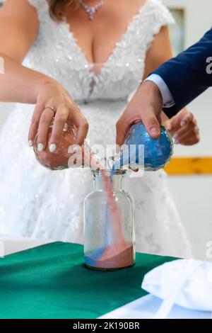 Mariée et marié versant des sables colorés de différentes couleurs dans le vase en cristal Banque D'Images