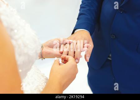 Pont mettant un anneau de mariage sur le doigt de Groom, cérémonie de mariage, isolé Banque D'Images