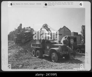 Des hommes du bataillon d'aviation des ingénieurs de 834th nettoient les débris des rues de la ville bombardée de Furth, en Allemagne. Banque D'Images