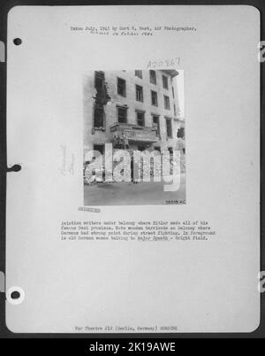 Aviation Writers sous balcon où Hitler a fait toutes ses célèbres promesses nazies. Notez la barricade en bois sur le balcon où les Allemands avaient un point fort pendant les combats de rue. Au premier plan se trouve une ancienne femme allemande qui parle au Maj Spaeth - Wright Fld. Banque D'Images