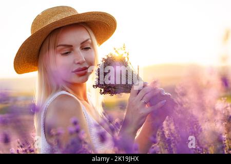 Portrait o charmante fille blonde sent les fleurs de lavande dans le champ de lavande Banque D'Images