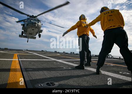 OCÉAN ATLANTIQUE (sept 14, 2022) le Mate 2nd de Boatswain, classe Kyle Jayroe, signale un hélicoptère MH-60s, affecté aux « Dragon Whales » de l'Escadron de combat de la mer (HSC) 28, avec le soutien du Mate 1st de Boatswain, classe Anthony Thomas, à bord du navire de combat littoral Freedom-variant USS Minneapolis-Saint Paul (LCS 21) pendant la certification MOB-A du navire, 14 septembre 2022. Minneapolis-Saint Paul est une propriété à la base navale de Mayport, en Floride. (É.-U. Photo de la marine par le spécialiste des communications de masse 2nd classe Juel Foster) Banque D'Images