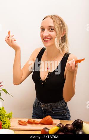 Belle blonde tient des légumes dans ses mains et sourit Banque D'Images