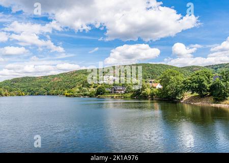 Quelques maisons au bord du lac Rursee, au milieu du parc national de l'Eifel, entouré par un paysage naturel unique et une nature préservée Banque D'Images