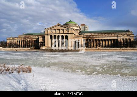 Chicago, Illinois, États-Unis. Le célèbre musée des sciences et de l'industrie photographié en hiver derrière un lagon gelé dans le parc Jackson, sur le côté sud de la ville. Banque D'Images