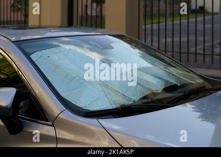 Surface réfléchissante protectrice sous le pare-brise de la voiture par temps chaud, chauffée par les rayons du soleil à l'intérieur de la voiture Banque D'Images