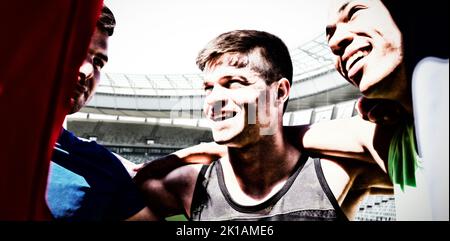 Des sportifs aux bras l'un autour de l'autre contre le stade de rugby à l'aube Banque D'Images