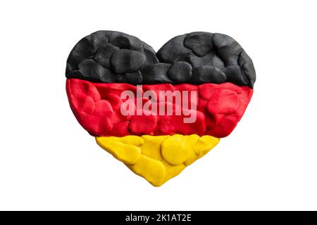 Forme de coeur de tricolore drapeau allemand plaline modelage argile isolée sur fond blanc. Drapeau noir, rouge et jaune de l'Allemagne. Doigt de plasticine t Banque D'Images