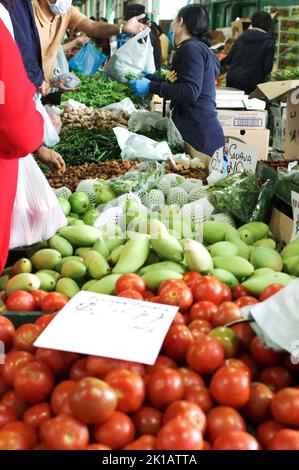 Un vendeur de Paddy’s Market à Flemington, Sydney, vend des mangues vertes, des tomates, des pommes Granny Smith, des haricots et d’autres fruits et légumes frais Banque D'Images
