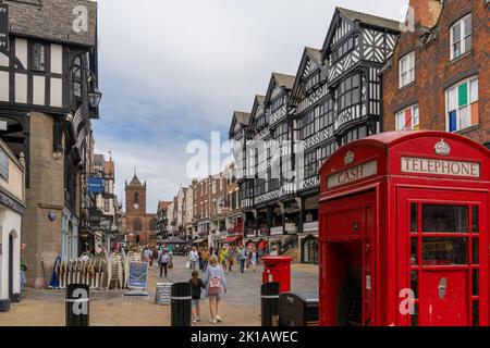 Chester, Royaume-Uni - 26 août 2022 : vue sur les maisons historiques à colombages du centre-ville de Chester avec un téléphone anglais rouge typique Banque D'Images