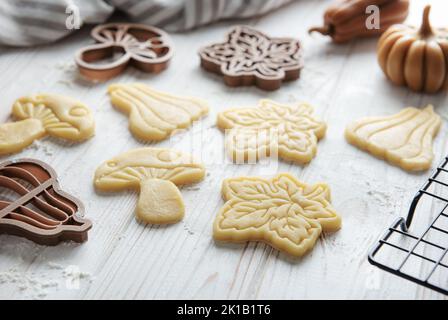 Cuisson de biscuits sous forme de citrouille et de feuilles. Pâtisserie d'automne confortable. Pâte avec emporte-pièces. Banque D'Images