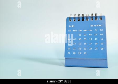 Objectif sélectif du calendrier de bureau de novembre 2022 sur fond bleu avec espace de copie. Banque D'Images