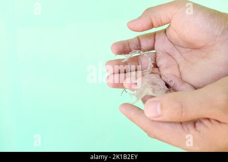 Concept d'entretien du dispositif de retenue. Main tenant les dispositifs de retenue dentaires hawley avec l'espace de copie. Banque D'Images