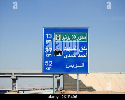 Suez, Egypte, 12 août 2022: Panneau de signalisation routière en arabe sur l'autoroute du Caire de Suez, Traduction (axe de 30 juin 13 KM, tunnel de Martyr Ahmed Hamdi 37 KM, su Banque D'Images