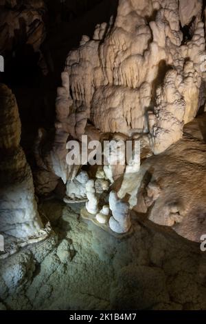 Formations rocheuses lisses et piscine d'eau dans l'intérieur de la grotte de Postojna en Slovénie. Banque D'Images