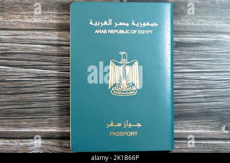 Passeport égyptien isolé sur fond de bois, passeport de la république arabe d'Égypte avec l'aigle d'or républicain sur sa couverture et le roi Toutankhamon Banque D'Images