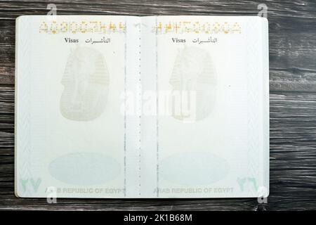 Passeport égyptien isolé sur fond de bois, passeport de la république arabe d'Égypte avec l'aigle d'or républicain sur sa couverture et le roi Toutankhamon Banque D'Images