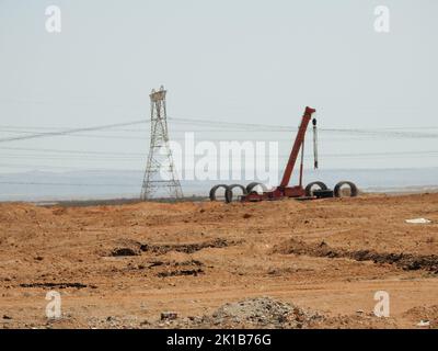 Suez, Egypte, 12 août 2022: Pelle pour camion-grue mobile et tour de puissance de transmission dans le désert à des fins de développement et de nouveaux projets dans par exemple Banque D'Images