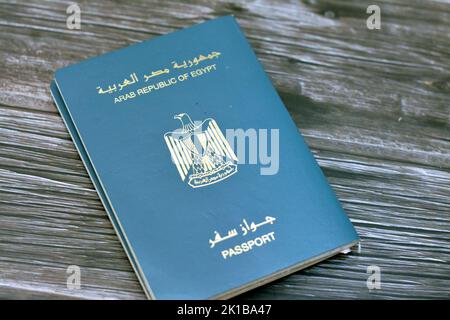 Passeport égyptien isolé sur fond de bois, passeport de la république arabe d'Égypte avec l'aigle d'or républicain sur sa couverture et le roi Toutankhamon Banque D'Images